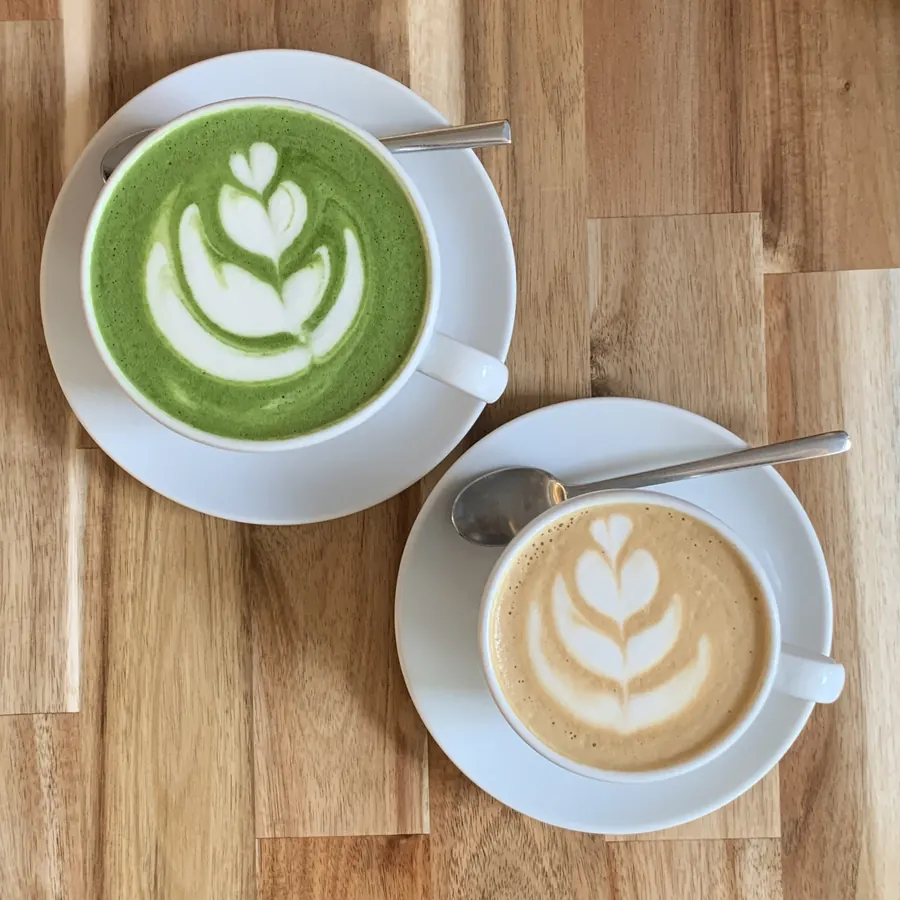 Matcha latte i cappuccino na drewnianym blacie